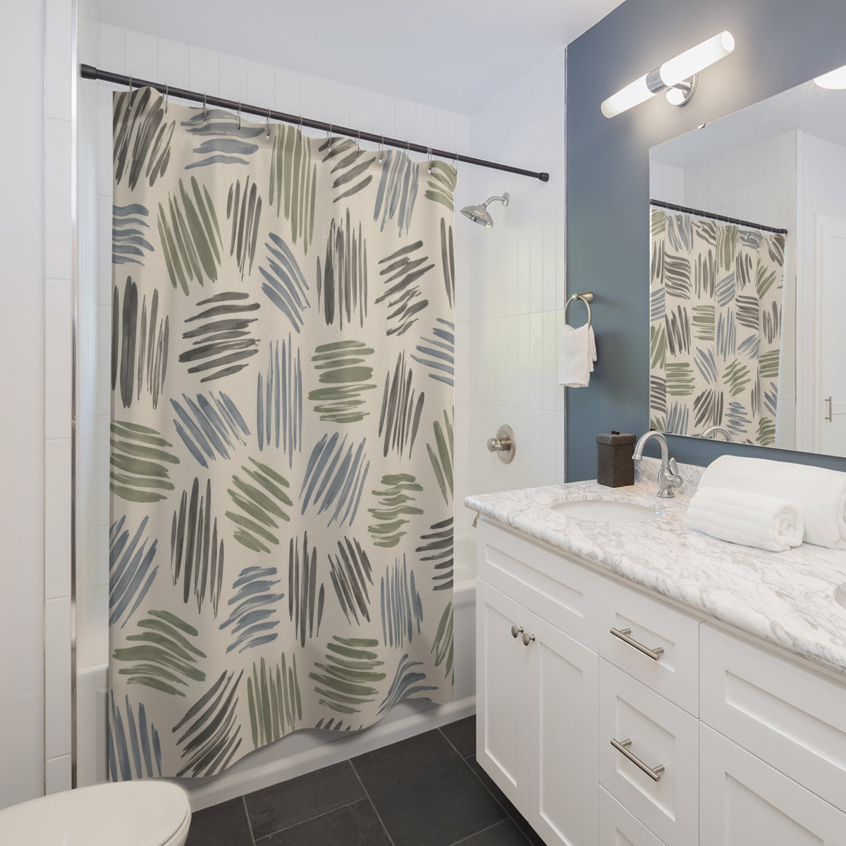 Sage, dusty blue and gray hatch marks on cream shower curtain beside a white vanity
