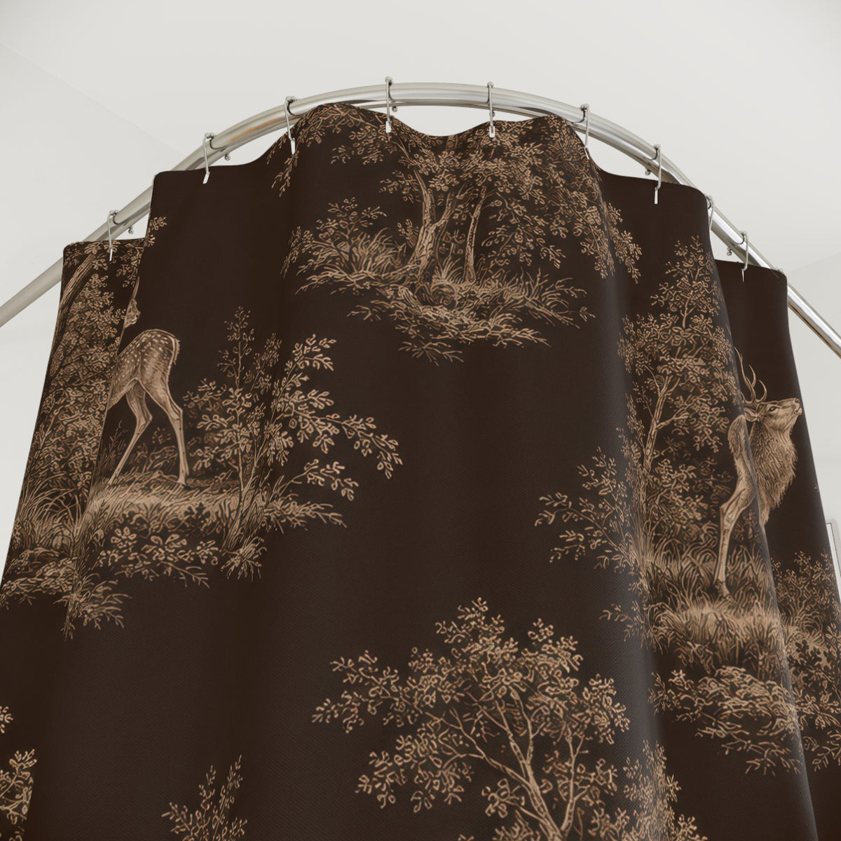 Beige deer and woodland trees on dark brown shower curtain with close-up print, hooks, and folds