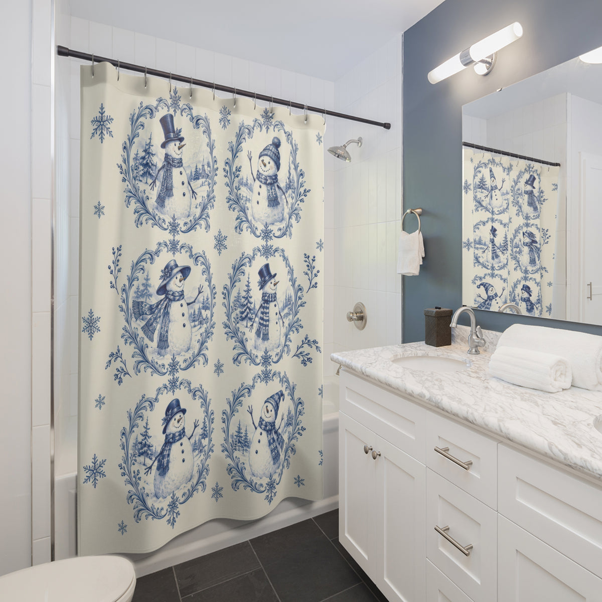 Blue snowman toile vignettes and snowflakes on ivory shower curtain beside a white vanity