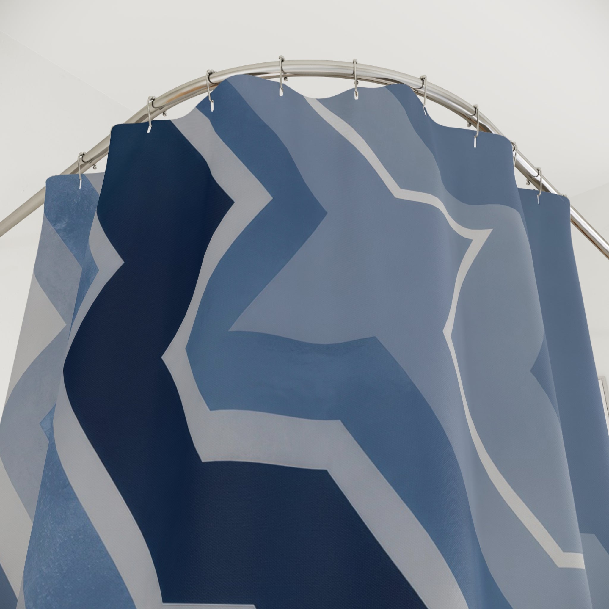 Blue and grey offset zigzag chevrons cascading diagonally shower curtain with close-up print, hooks, and folds
