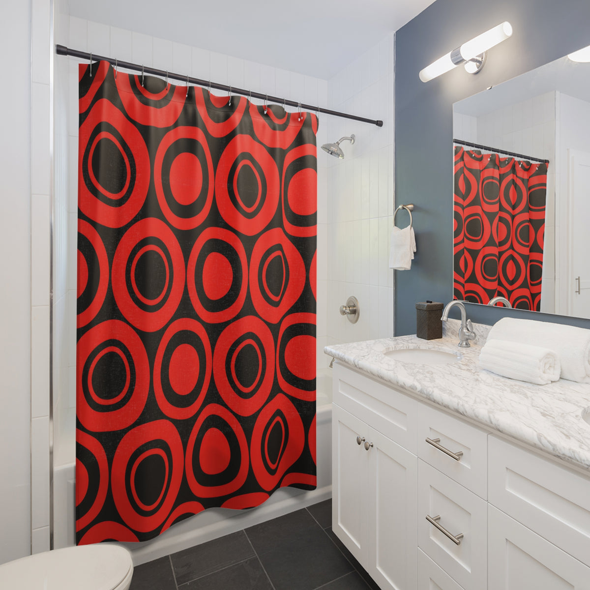 Red concentric circles and black circular bands shower curtain beside a white vanity