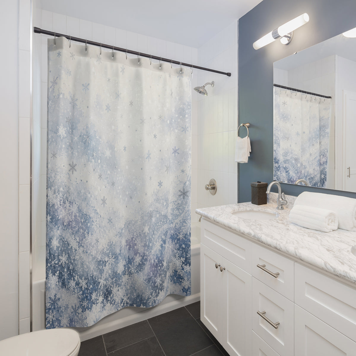 Pale blue watercolor snowfall shower curtain beside a white vanity