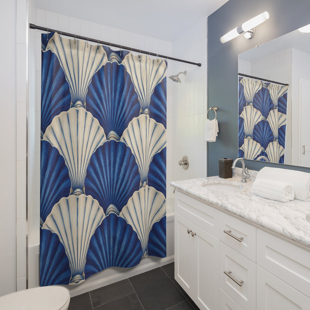 Overlapping cobalt blue and ivory scallop shells shower curtain beside a white vanity