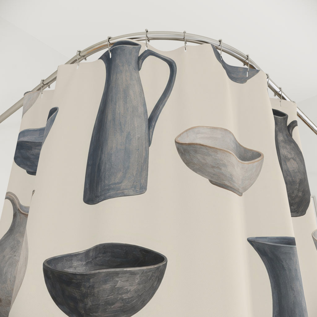 Blue-gray pitchers and bowls with charcoal accents on cream shower curtain with close-up print, hooks, and folds