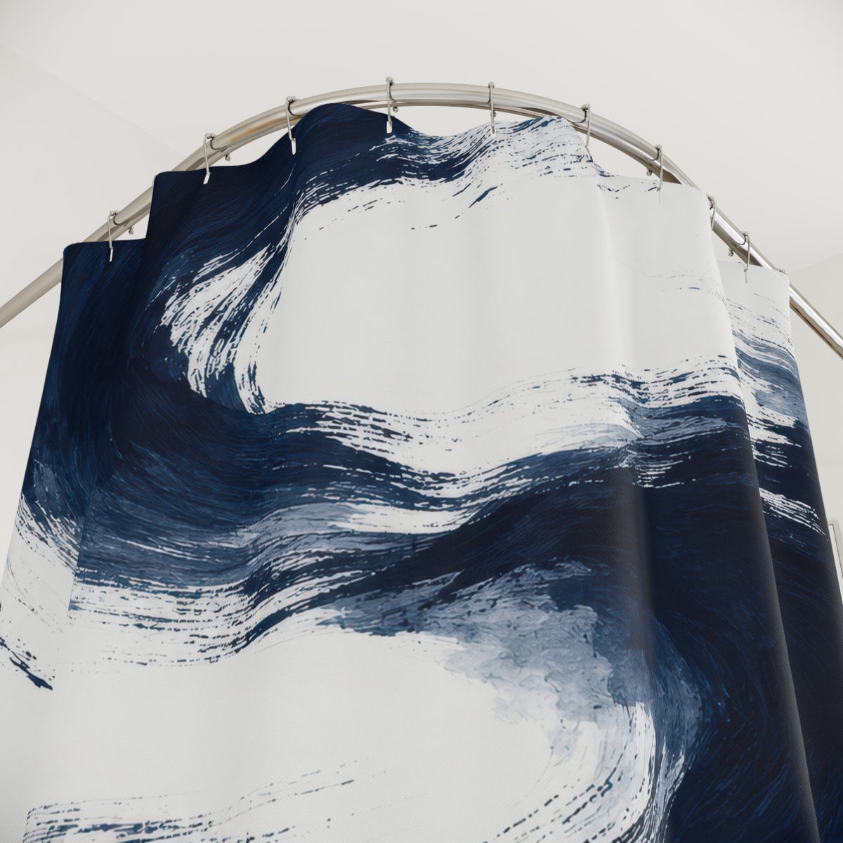 Sweeping navy brushstrokes and pale blue washes on white shower curtain with close-up print, hooks, and folds