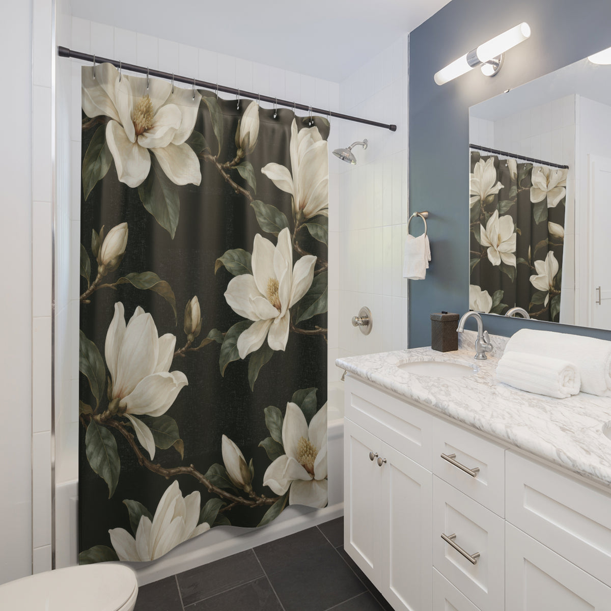 Creamy-white magnolias and olive leaves on dark green shower curtain beside a white vanity