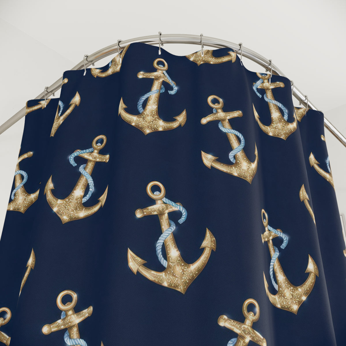 Gold-colored anchors and blue ropes on navy shower curtain with close-up print, hooks, and folds