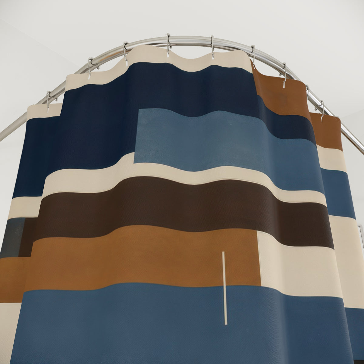 Blue and brown staggered horizontal bars on cream shower curtain with close-up print, hooks, and folds