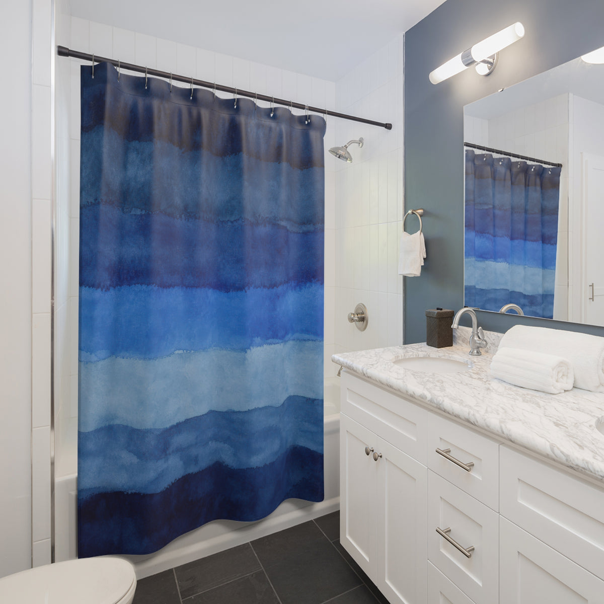Navy Cobalt Horizontal Watercolor Bands shower curtain beside a white vanity
