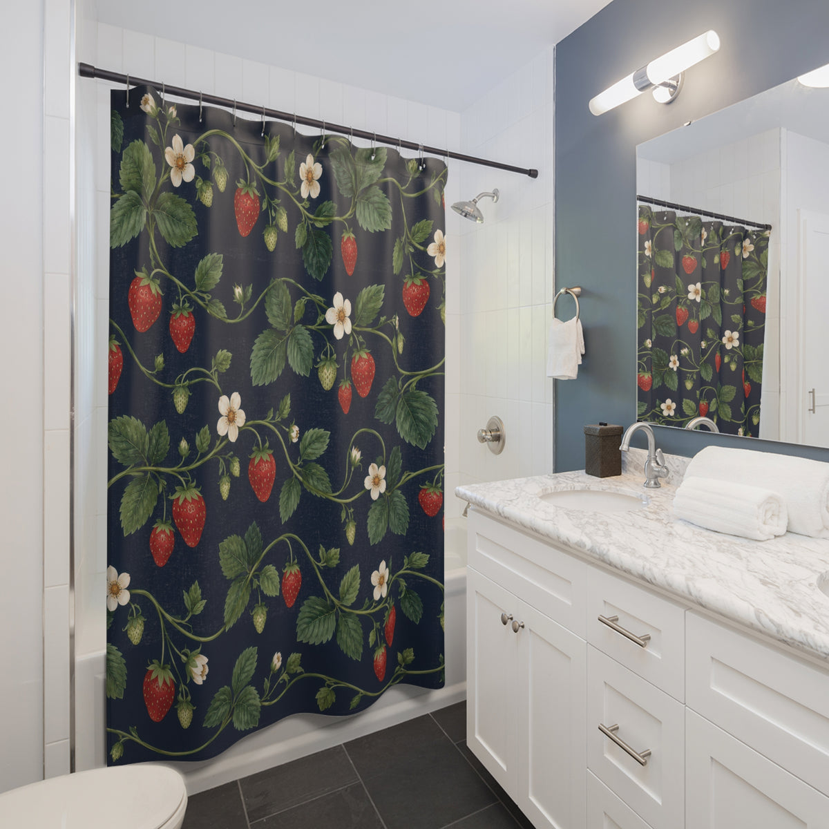 Red strawberries and ivory flowers on navy shower curtain beside a white vanity