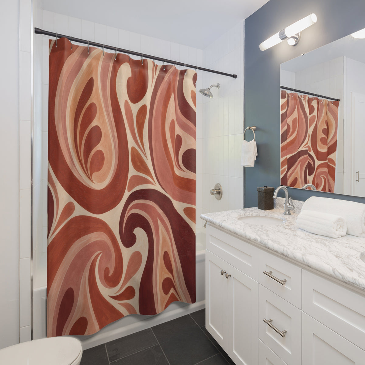 Oversized terracotta, blush and wine paisley curls shower curtain beside a white vanity