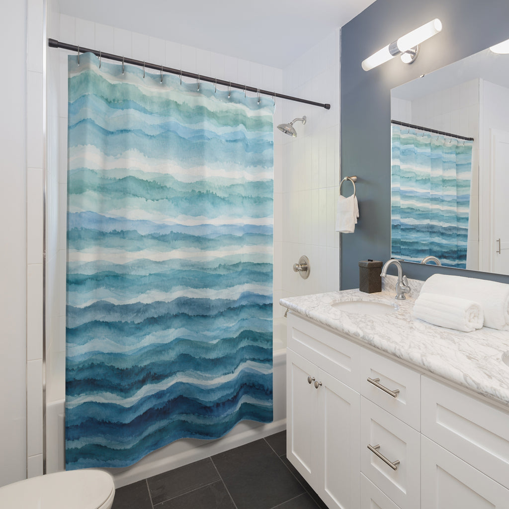 Watercolor bands of aqua and teal deepening to blue below shower curtain beside a white vanity