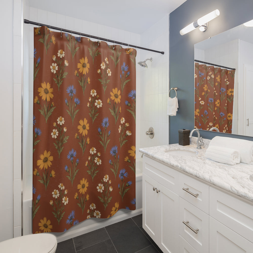 Ochre flowers, blue cornflowers and cream daisies on russet shower curtain beside a white vanity