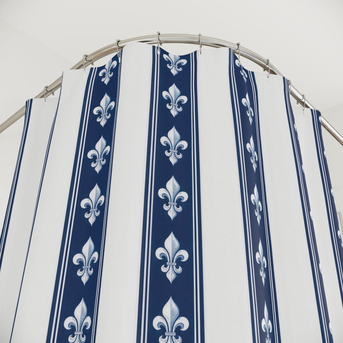 White fleur-de-lis motifs in navy and white vertical bands shower curtain with close-up print, hooks, and folds