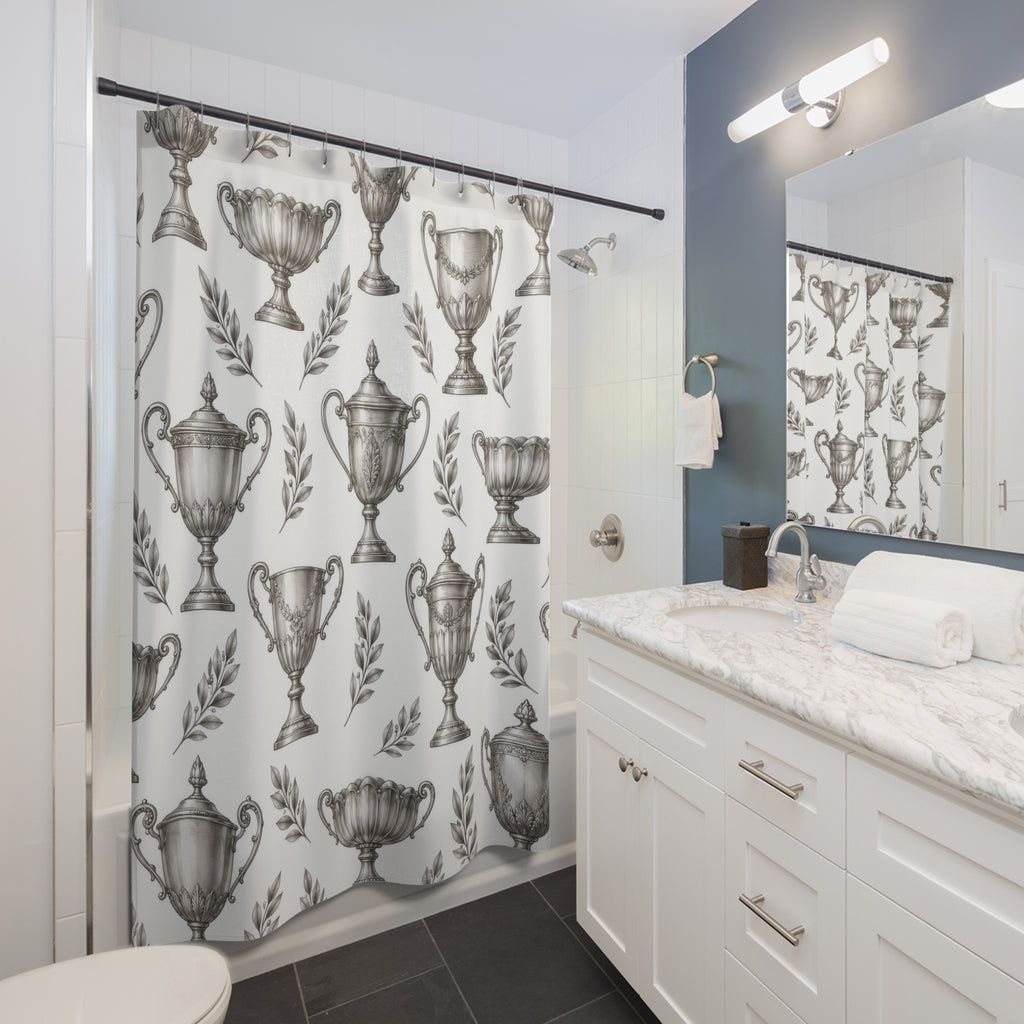 Silver trophy cups and gray laurel sprigs shower curtain beside a white vanity