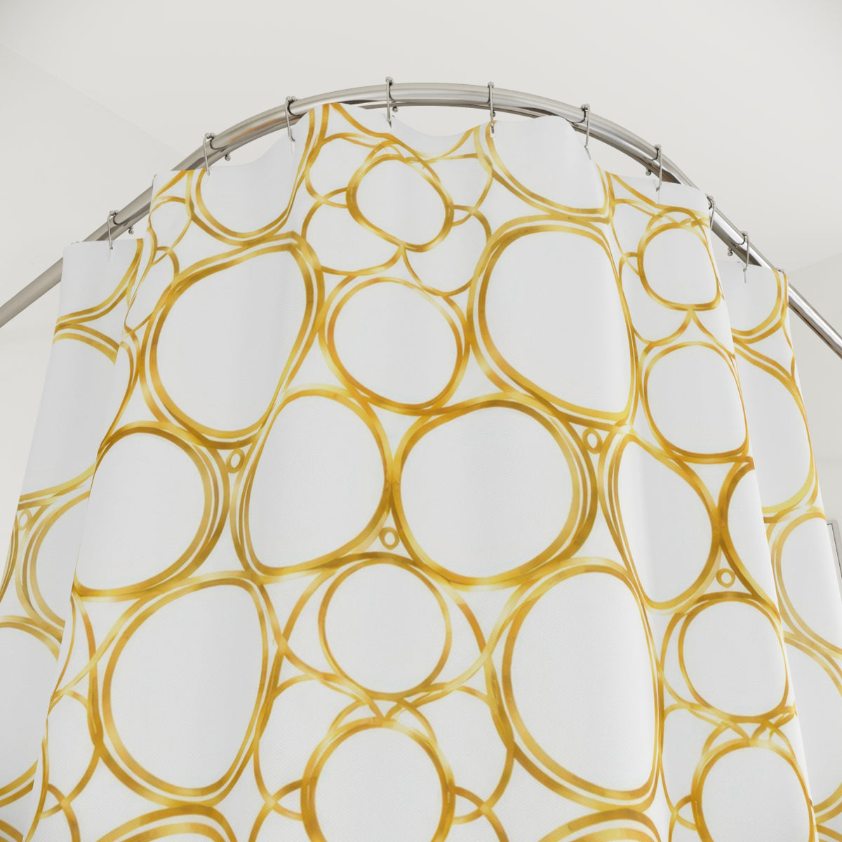 Gold halo circle pattern on warm white shower curtain with close-up print, hooks, and folds