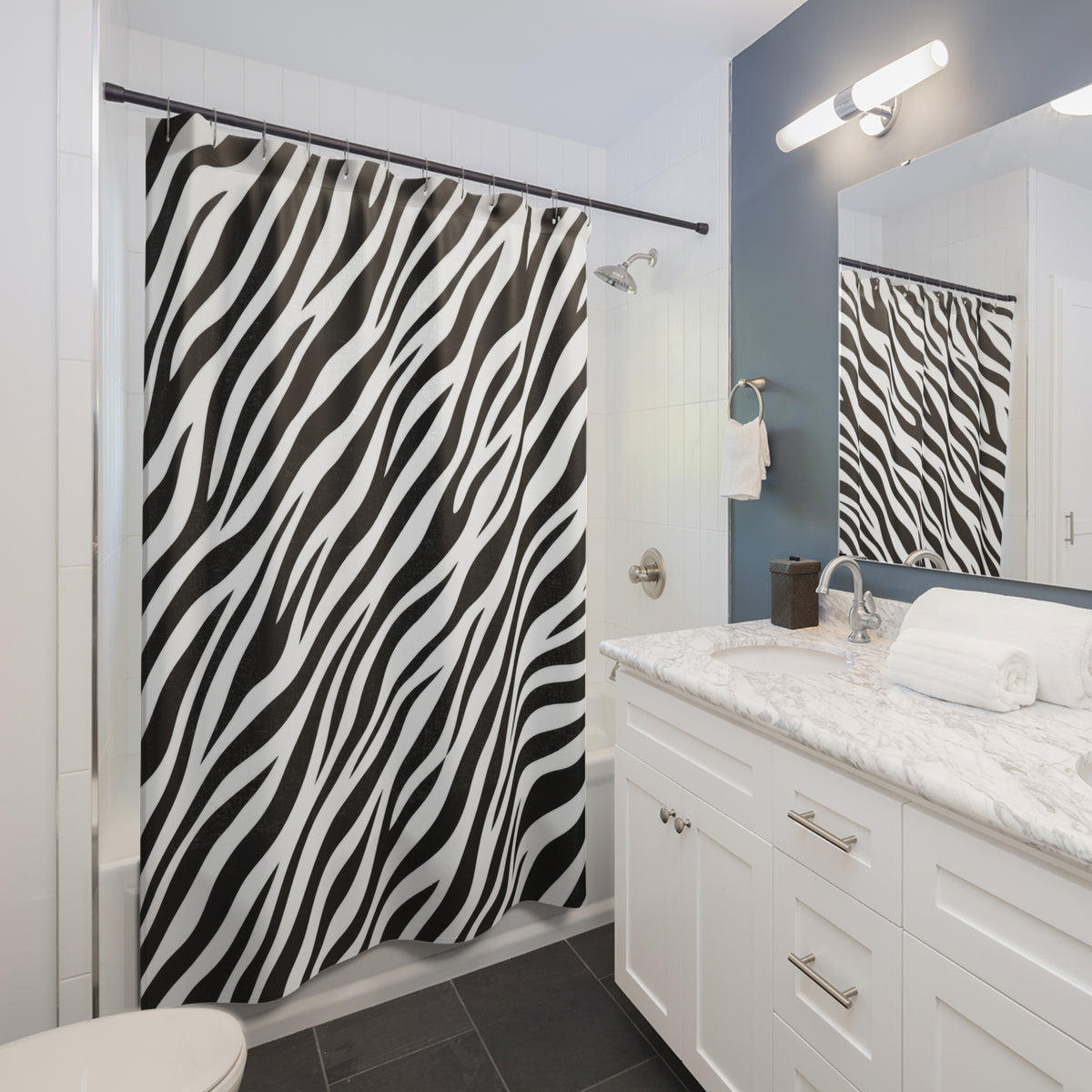 Diagonal black zebra stripes tapering across white shower curtain beside a white vanity