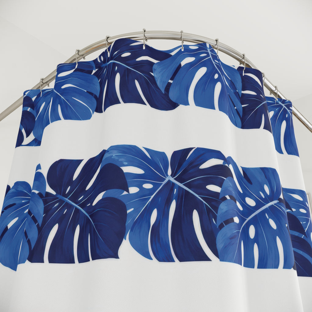 Cobalt monstera leaf bands alternating with white stripes shower curtain with close-up print, hooks, and folds
