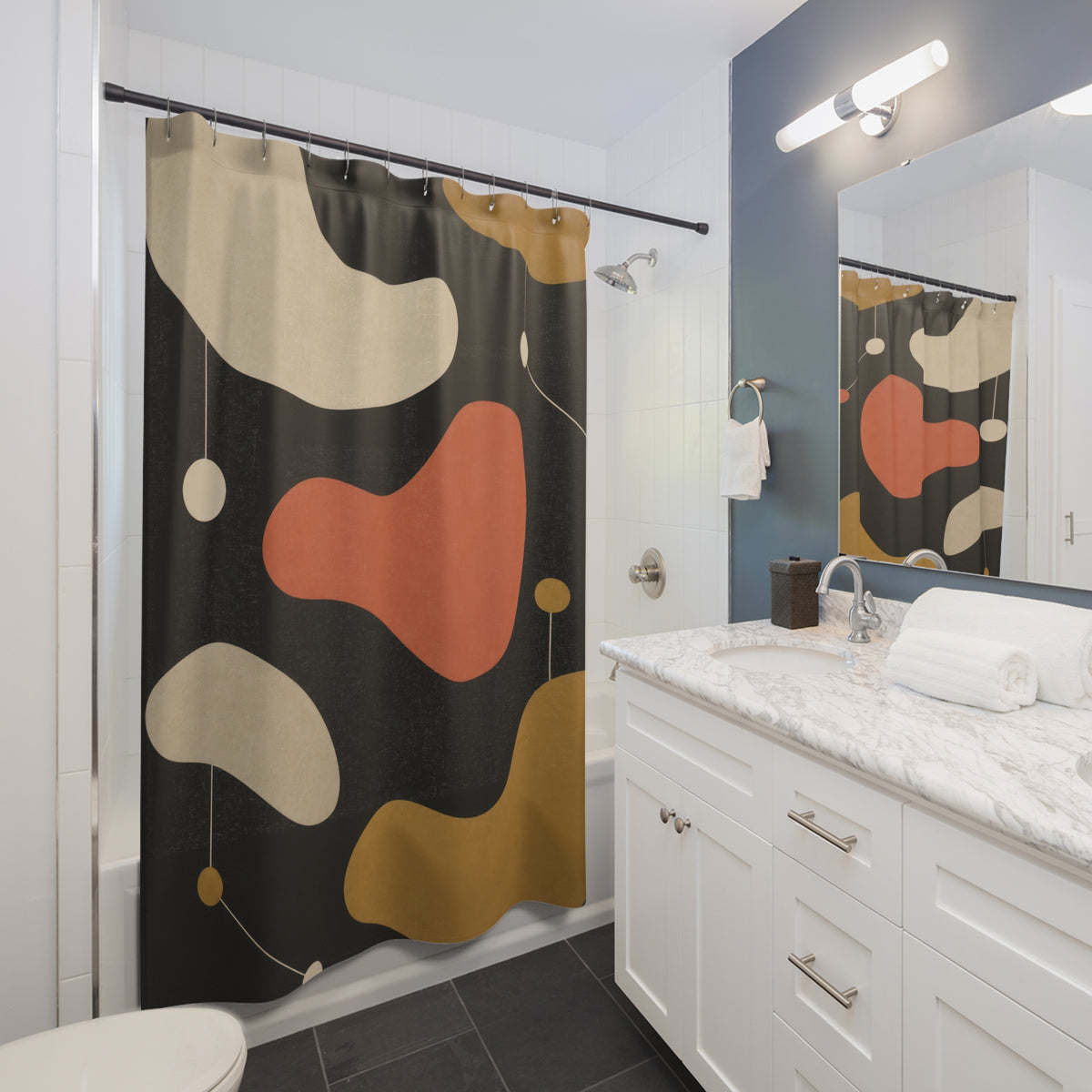 Cream, coral and ochre kidney shapes on charcoal shower curtain beside a white vanity