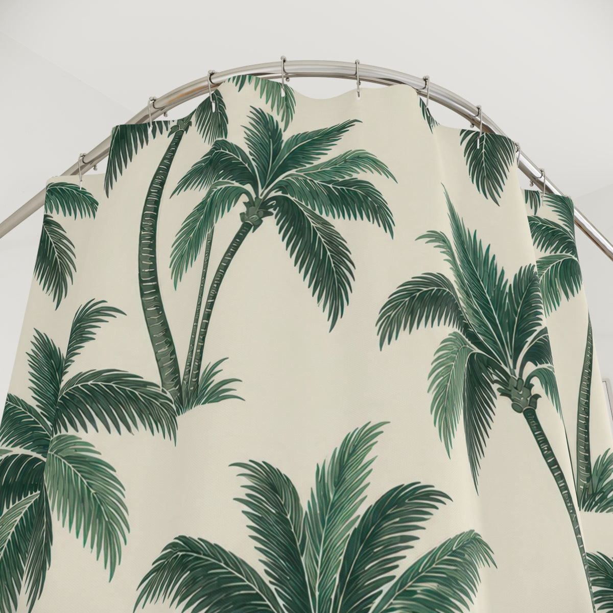 Green palm trees with curved trunks on warm cream shower curtain with close-up print, hooks, and folds