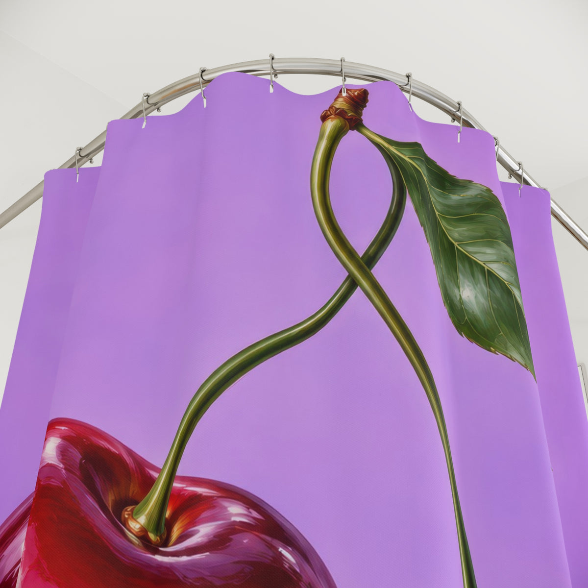 Two glossy red cherries with green stems on lilac shower curtain with close-up print, hooks, and folds