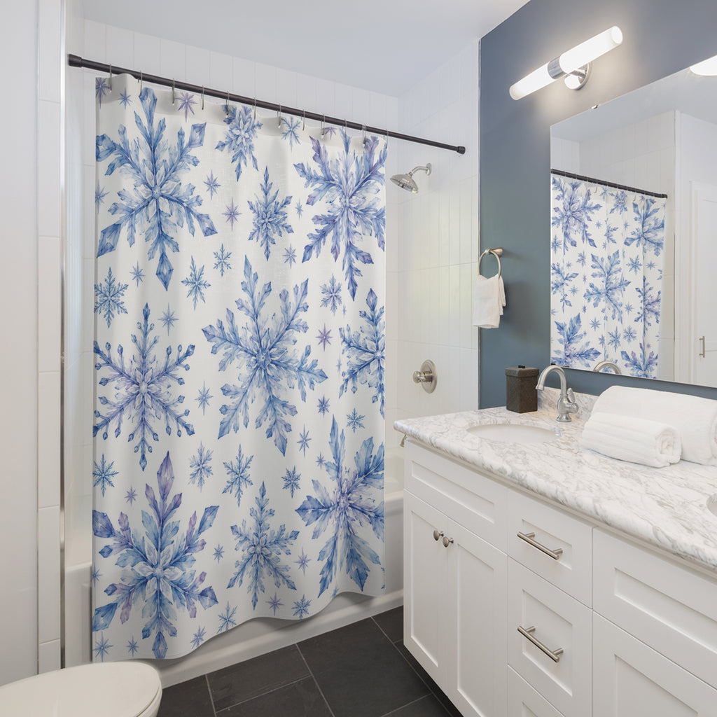 Blue and lilac watercolor snowflakes on white shower curtain beside a white vanity