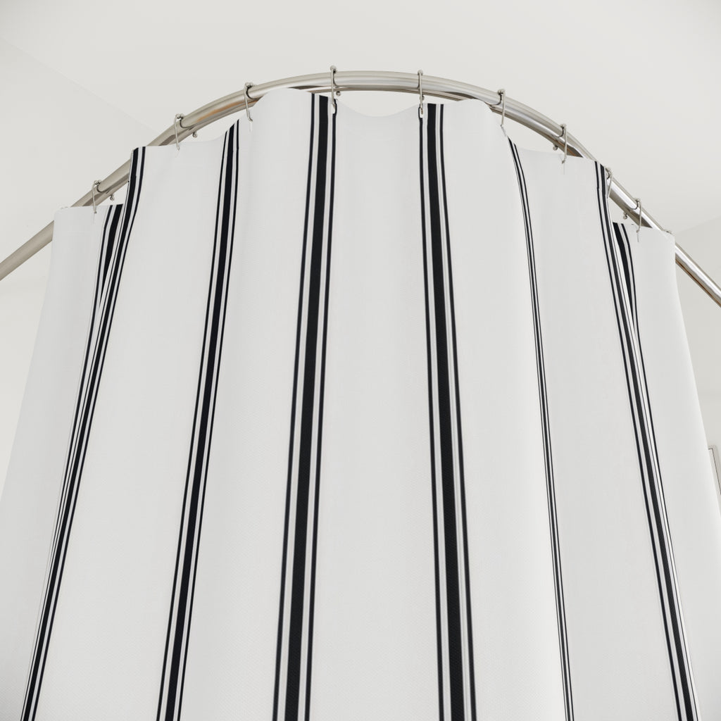 Black vertical ticking triplets on a white ground shower curtain with close-up print, hooks, and folds