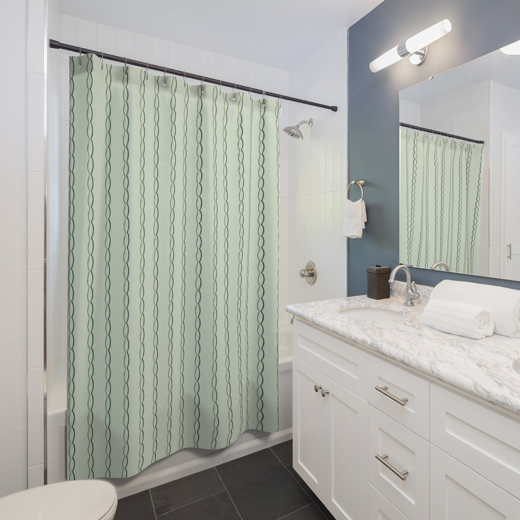 Paired olive and teal scalloped vertical lines on mint shower curtain beside a white vanity