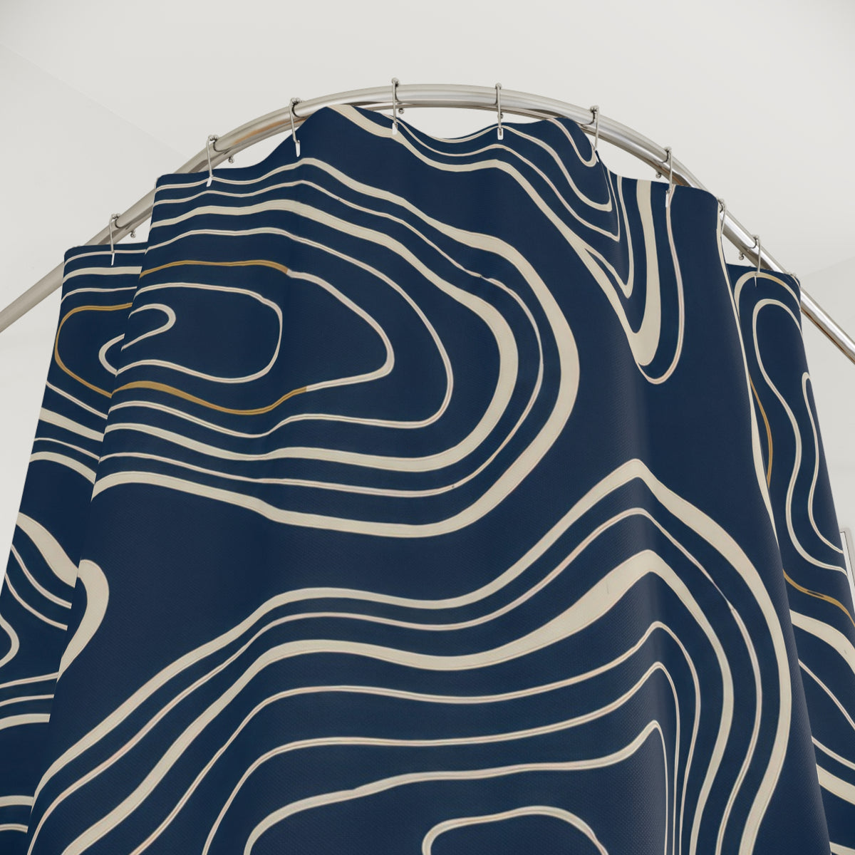 Cream nested contours and ochre accents on navy shower curtain with close-up print, hooks, and folds