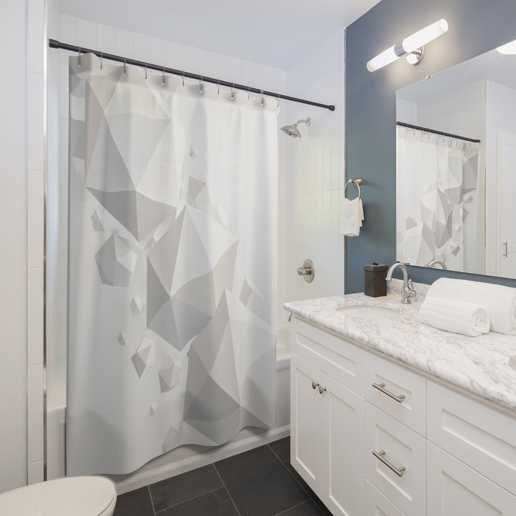 Floating white polyhedra cascading across a pale mist-gray field shower curtain beside a white vanity