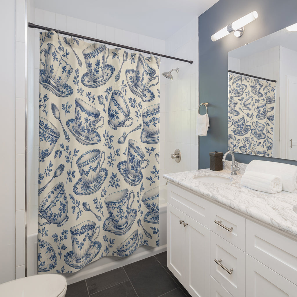 Blue floral teacups and saucers on cream shower curtain beside a white vanity