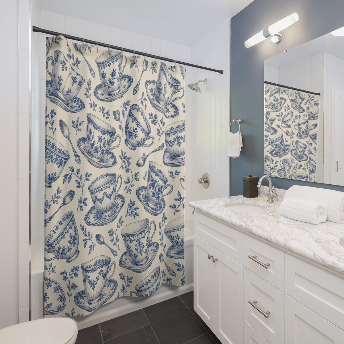 Blue floral teacups and saucers on cream shower curtain beside a white vanity