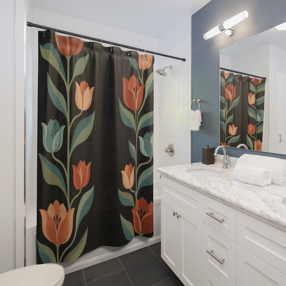 Terracotta tulips, closed teal buds and sage leaves on black shower curtain beside a white vanity