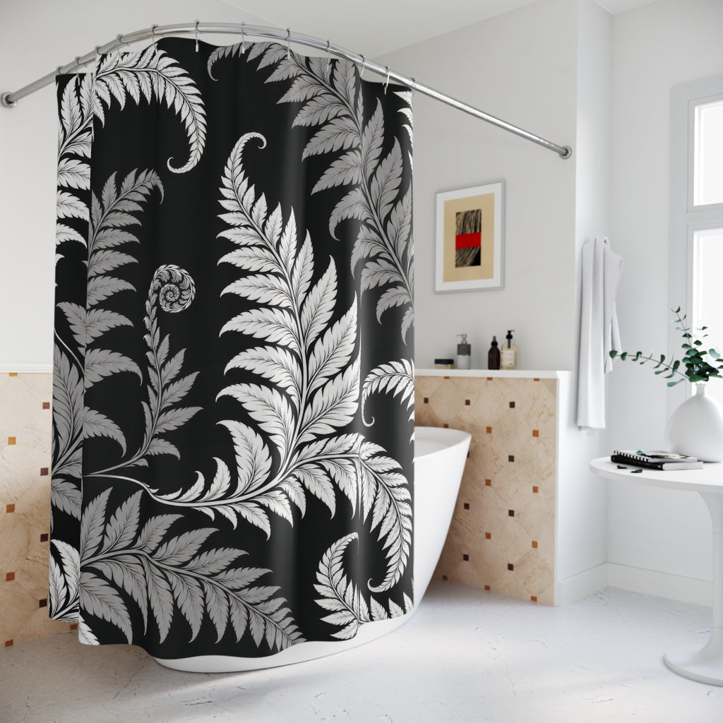 White and gray curling fern fronds on a black ground shower curtain beside a freestanding tub