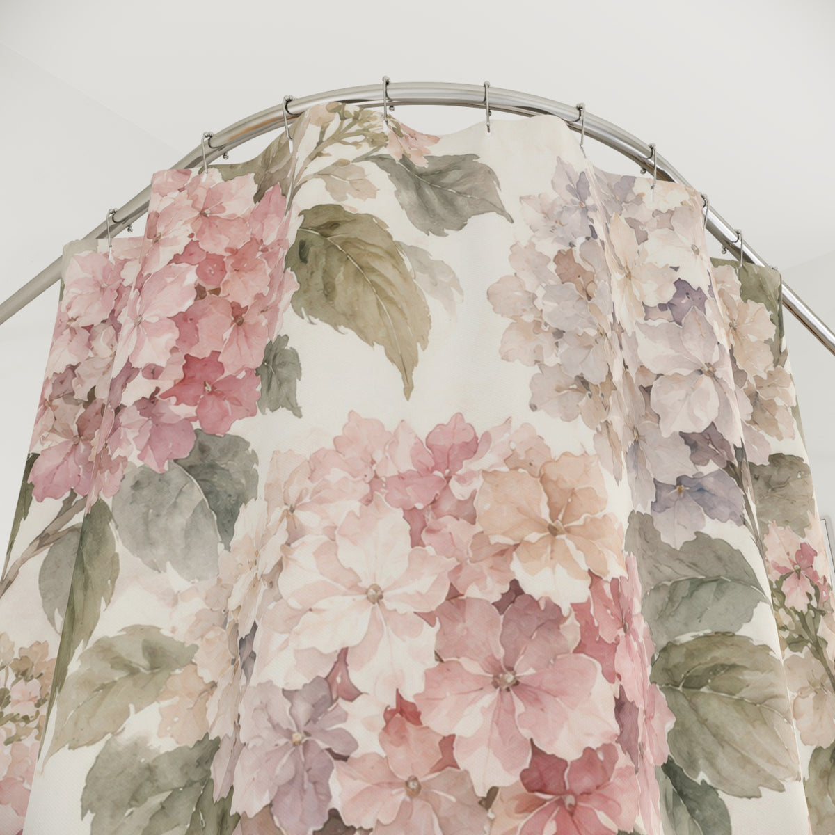 Blush hydrangeas and sage leaves on cream shower curtain with close-up print, hooks, and folds