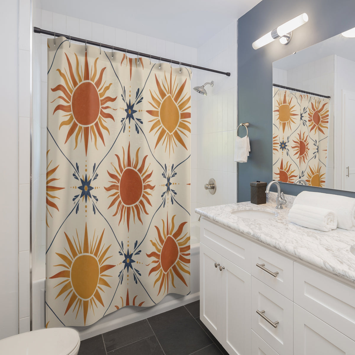 Terracotta and ochre suns with indigo stars on cream shower curtain beside a white vanity