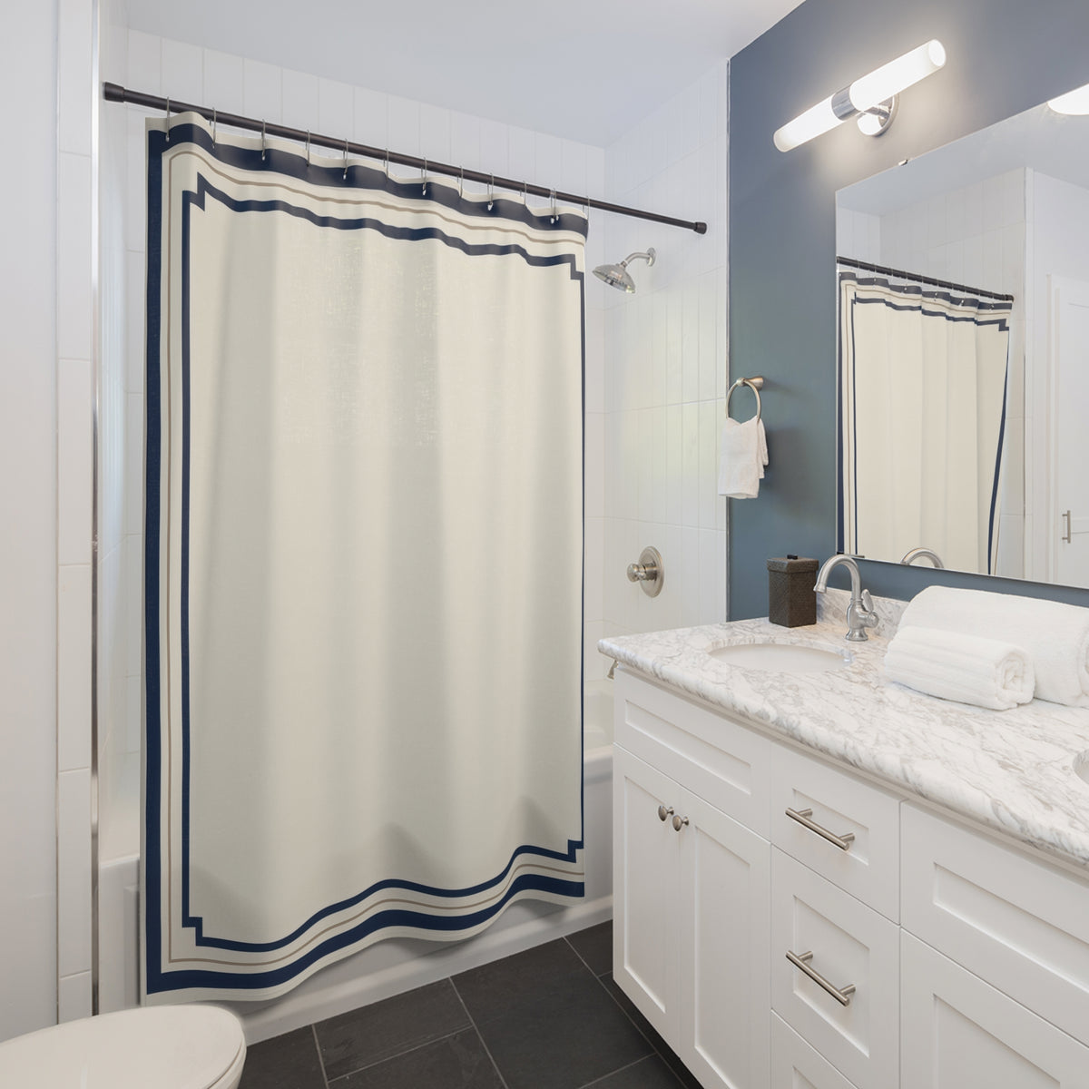 Navy stepped borders around an ivory center shower curtain beside a white vanity