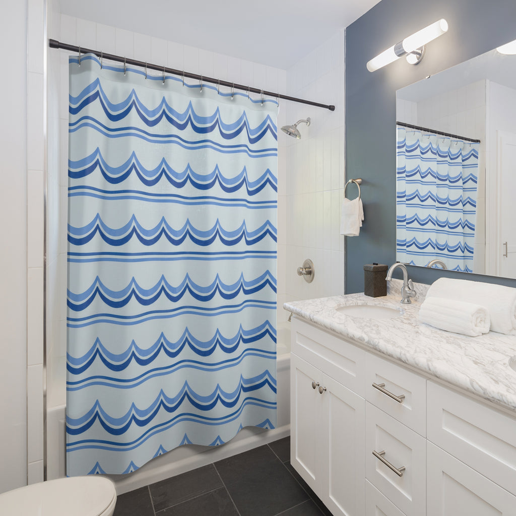 Cornflower and cobalt scallop bands on pale blue shower curtain beside a white vanity