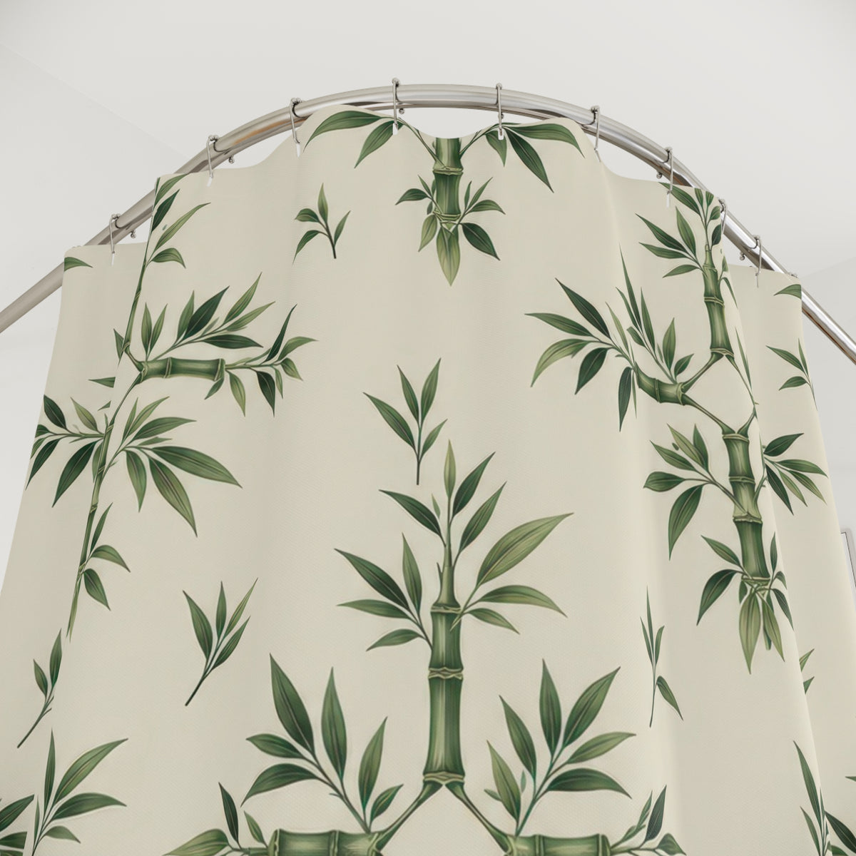 Sage bamboo ornaments and leaf sprigs on cream shower curtain with close-up print, hooks, and folds