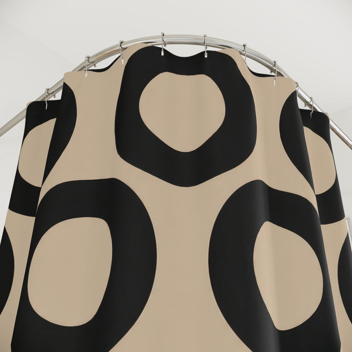 Beige and black open circles shower curtain with close-up print, hooks, and folds