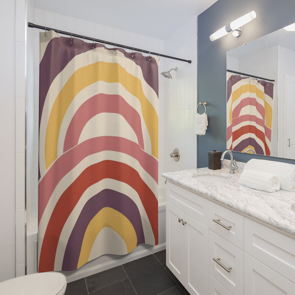 Nested wide arch stripes in plum yellow rose cream and brick shower curtain beside a white vanity