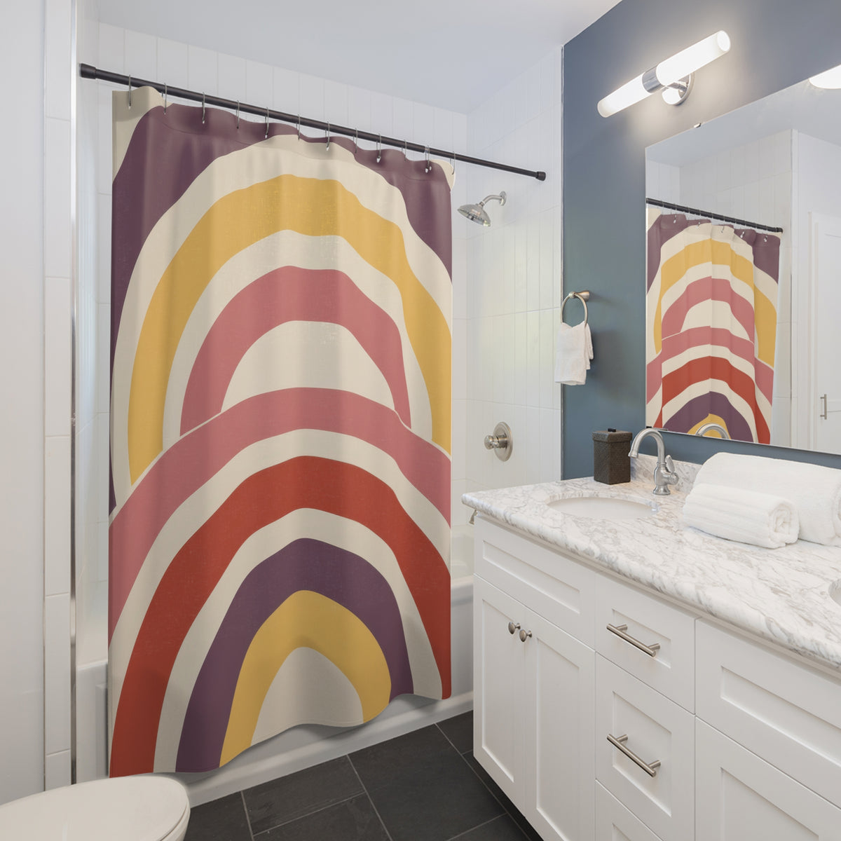 Nested wide arch stripes in plum yellow rose cream and brick shower curtain beside a white vanity