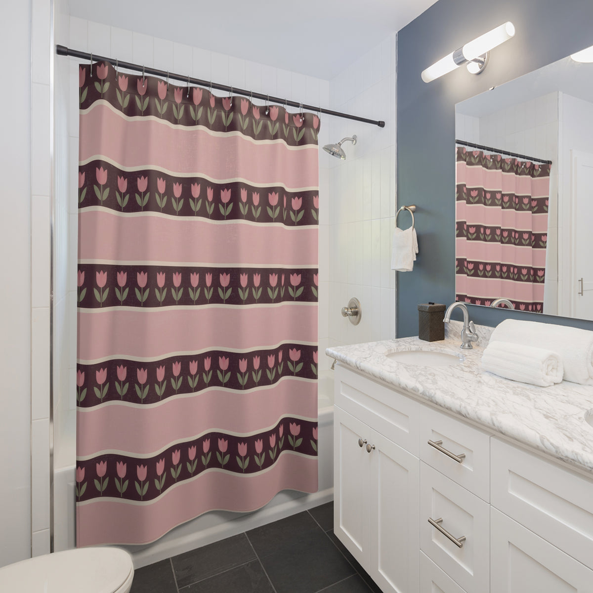 Pink tulip rows on plum bands between broad blush stripes shower curtain beside a white vanity