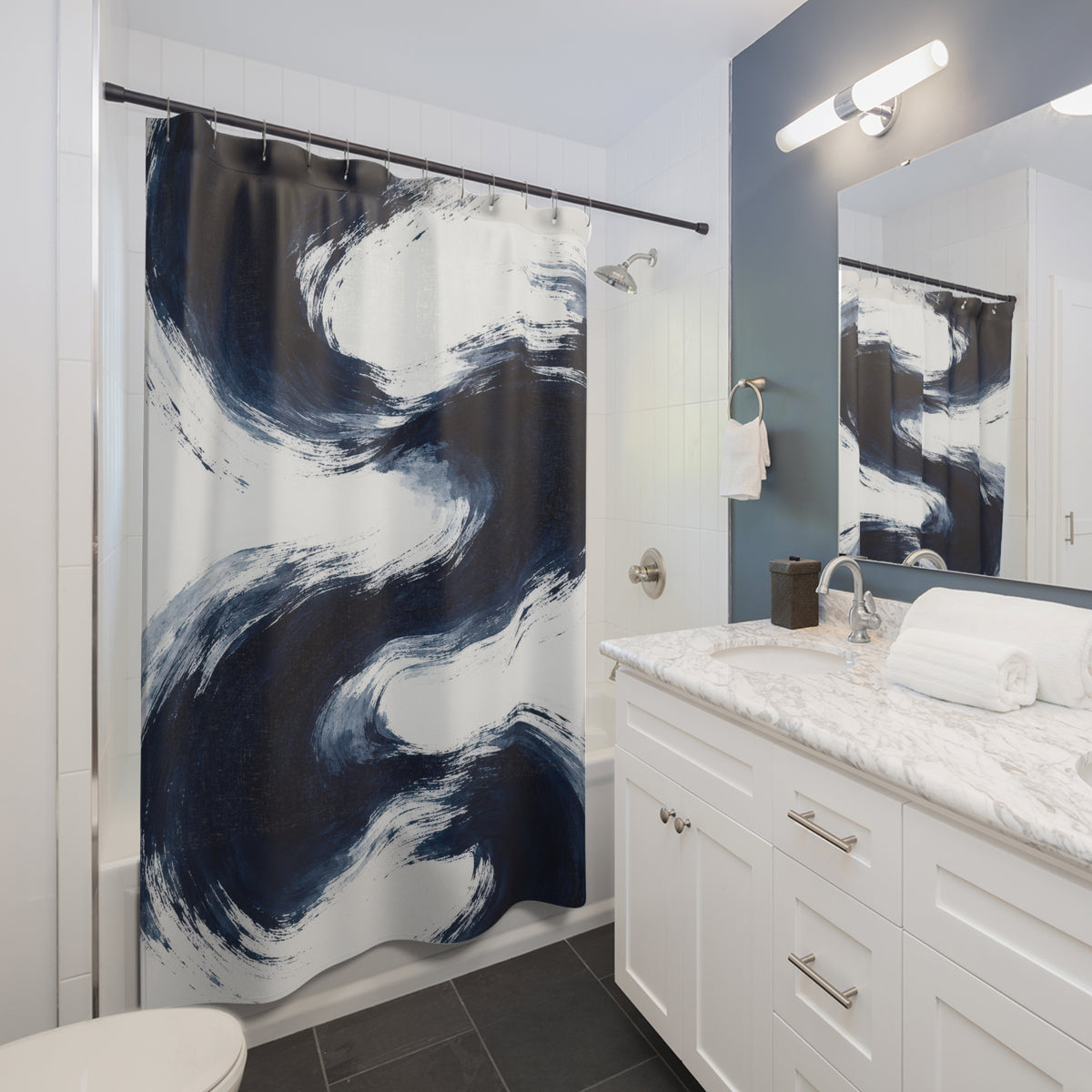 Sweeping navy brushstrokes and pale blue washes on white shower curtain beside a white vanity