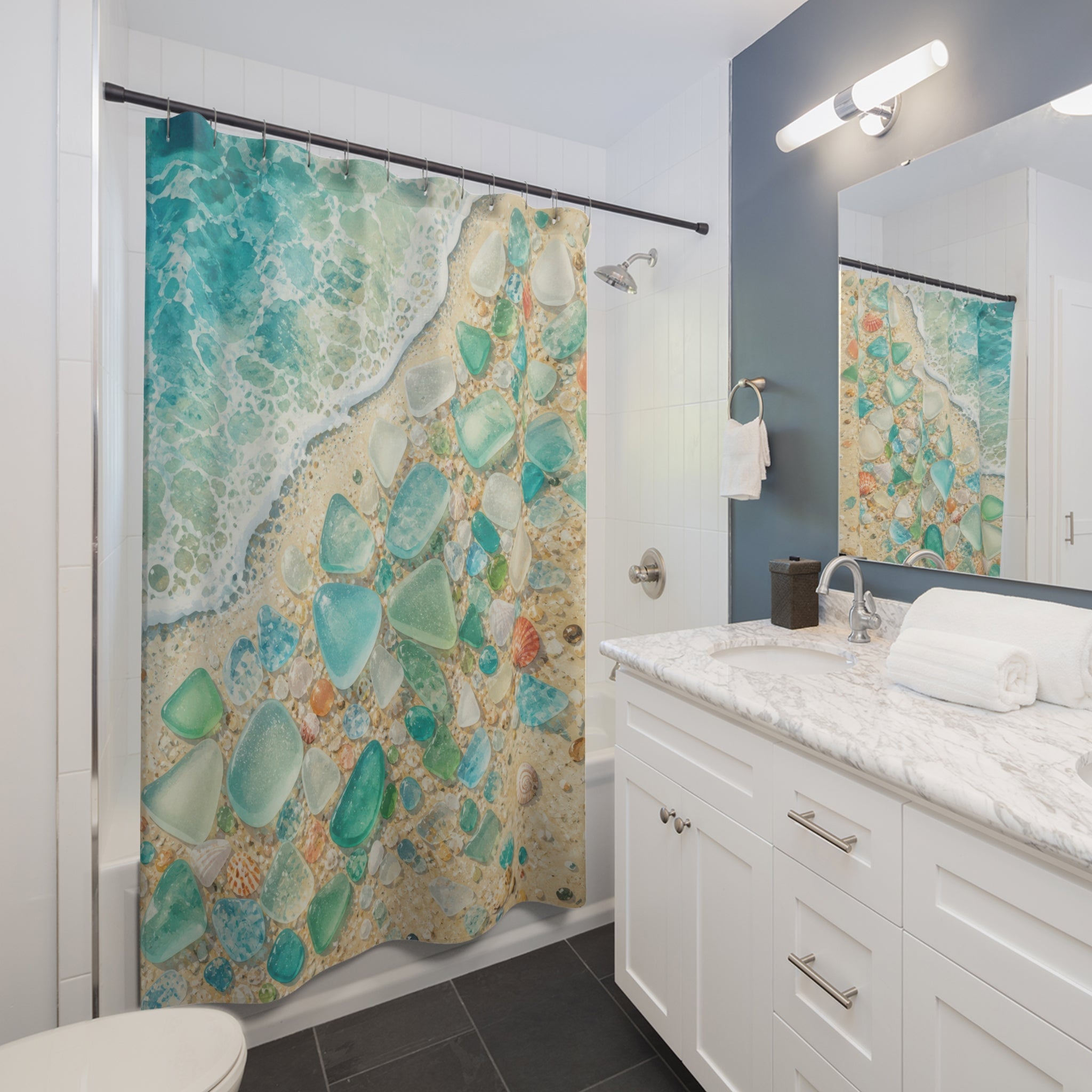Sea glass and shells beside a turquoise shoreline shower curtain installed beside a white vanity