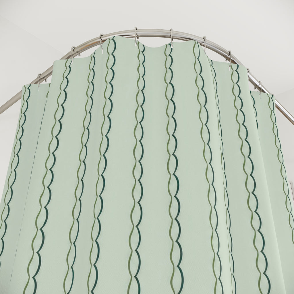 Paired olive and teal scalloped vertical lines on mint shower curtain with close-up print, hooks, and folds