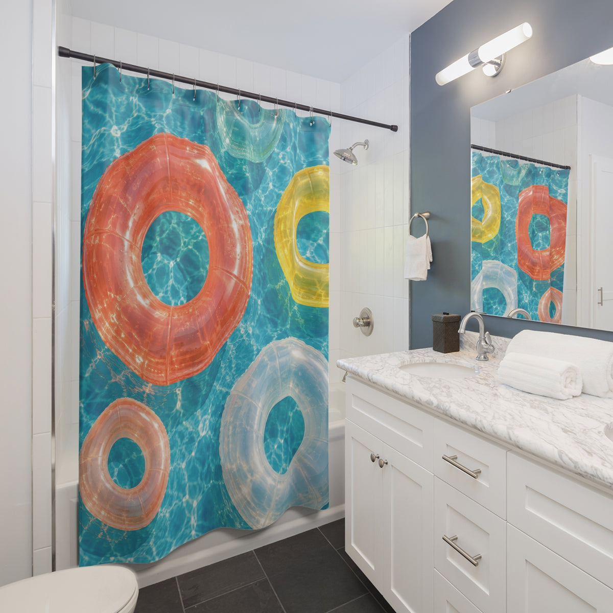Coral, yellow and white pool floats on sunlit aqua water shower curtain beside a white vanity