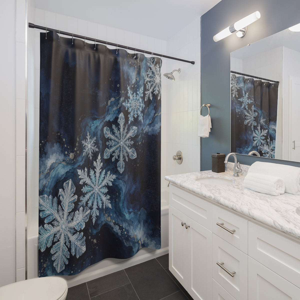 Midnight blue snowflake cascade shower curtain beside a white vanity