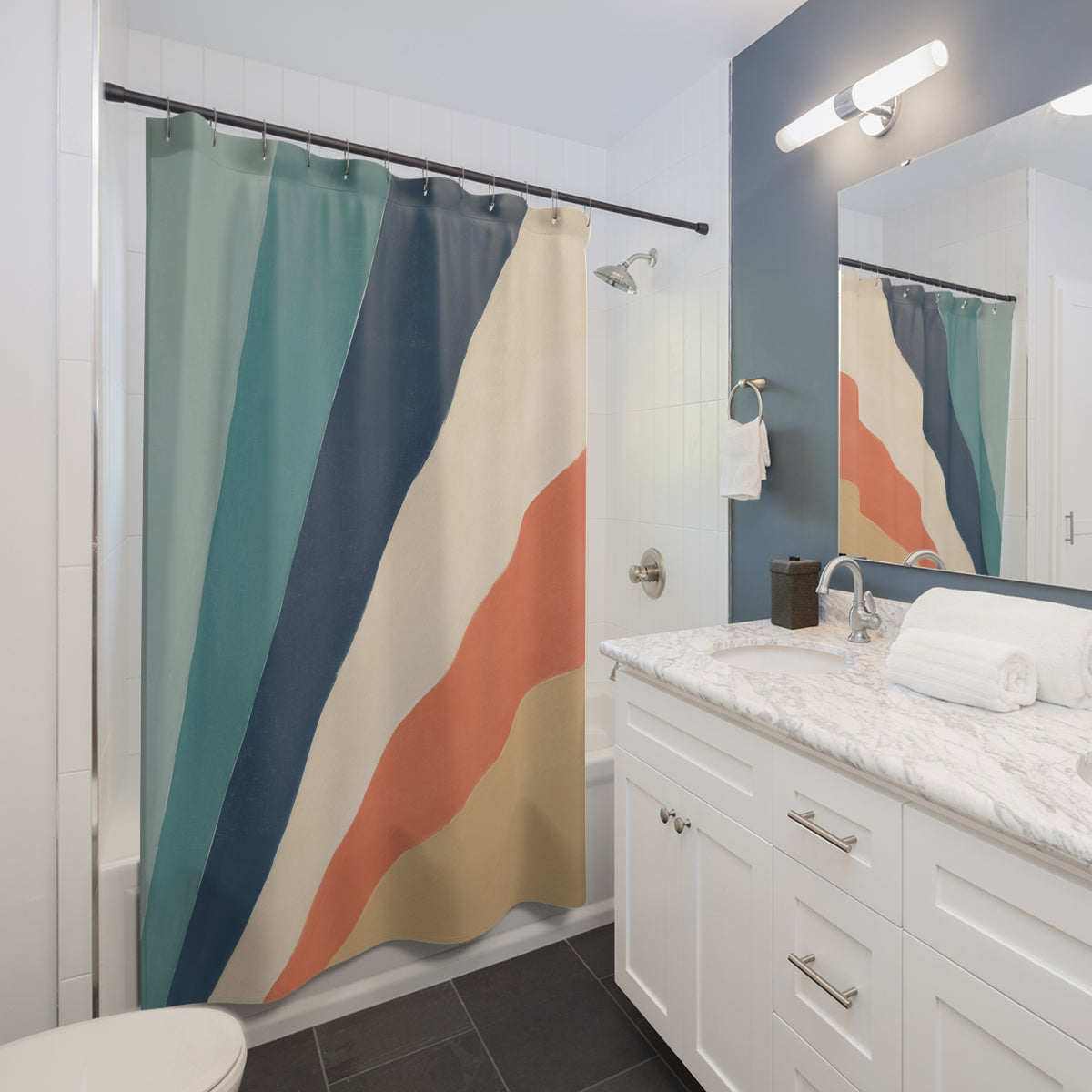Radiating wide teal navy coral gold and cream stripes shower curtain beside a white vanity