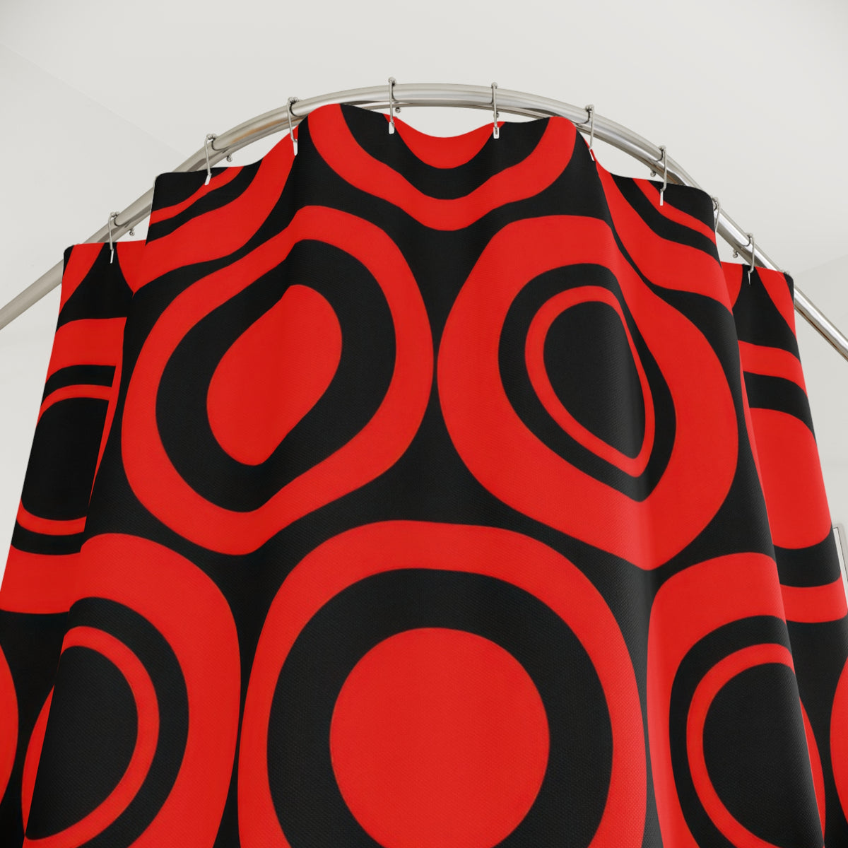 Red concentric circles and black circular bands shower curtain with close-up print, hooks, and folds